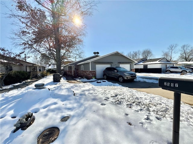 snow covered property with a garage