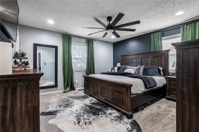 carpeted bedroom with ceiling fan and a textured ceiling