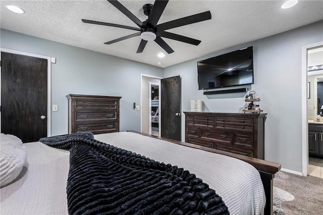 bedroom featuring ensuite bath, a textured ceiling, ceiling fan, and carpet