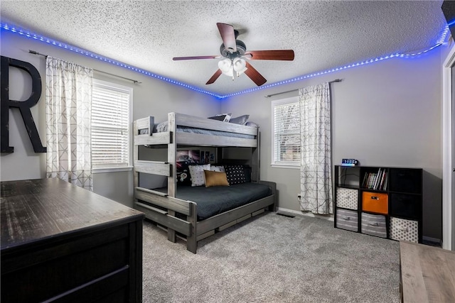 bedroom featuring a textured ceiling, ceiling fan, and carpet flooring