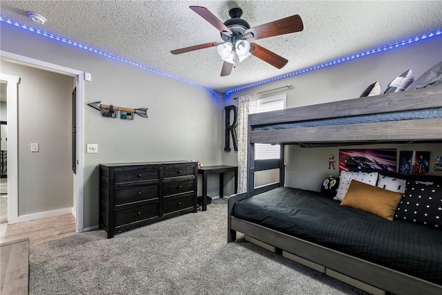 bedroom with hardwood / wood-style flooring, a textured ceiling, and ceiling fan