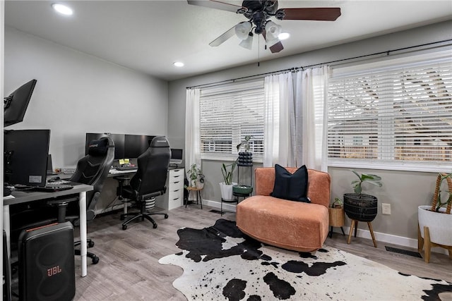 office space with a healthy amount of sunlight, ceiling fan, and light hardwood / wood-style flooring