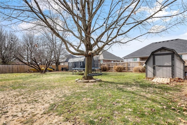 view of yard featuring a trampoline and a storage shed