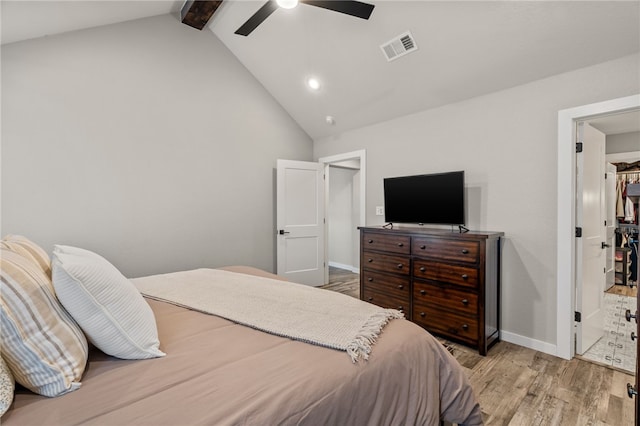 bedroom with ceiling fan, connected bathroom, light hardwood / wood-style floors, and lofted ceiling with beams