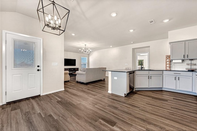 kitchen featuring pendant lighting, backsplash, dark hardwood / wood-style flooring, kitchen peninsula, and an inviting chandelier