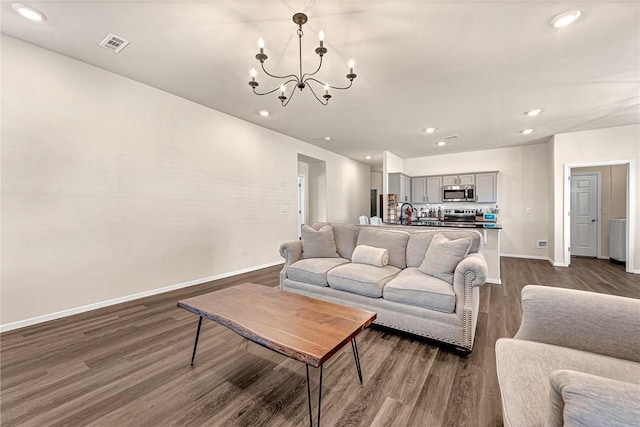 living room with dark hardwood / wood-style flooring, sink, and an inviting chandelier