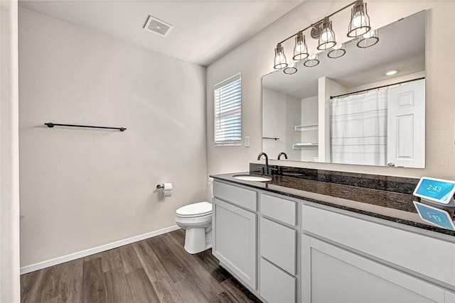 bathroom with wood-type flooring, a shower with shower curtain, vanity, and toilet