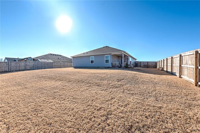 rear view of house featuring a yard