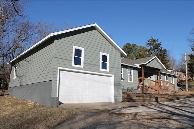 view of side of property with a garage and covered porch