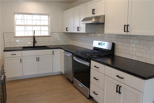 kitchen featuring tasteful backsplash, white cabinetry, sink, stainless steel appliances, and light hardwood / wood-style flooring