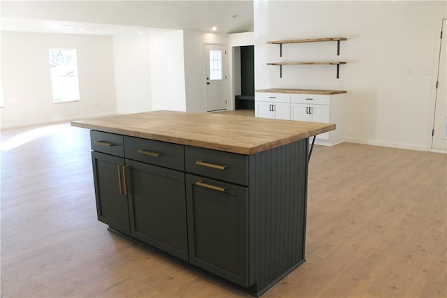 kitchen featuring wood counters, a wealth of natural light, a center island, and white cabinets