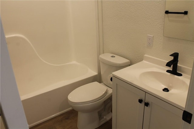 full bathroom featuring hardwood / wood-style flooring, vanity, bathing tub / shower combination, and toilet