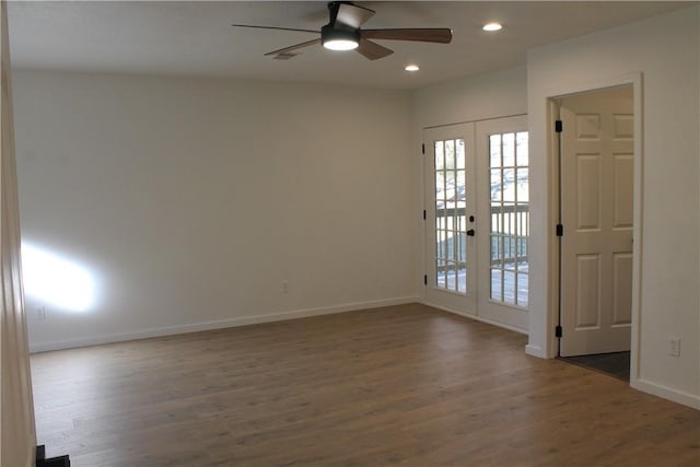 spare room featuring dark wood-type flooring, french doors, and ceiling fan