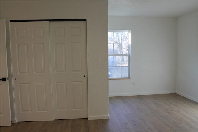 unfurnished bedroom with light hardwood / wood-style flooring and a closet