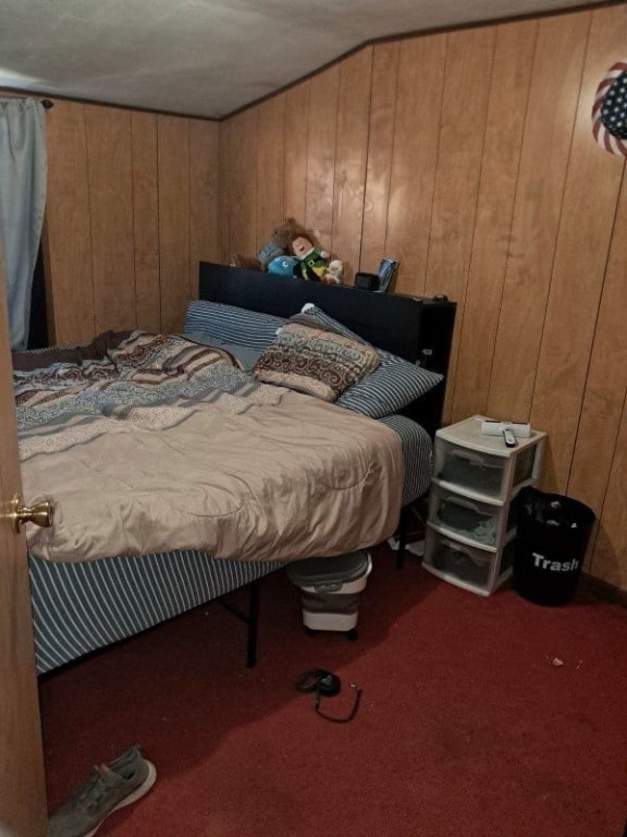 carpeted bedroom with wooden walls