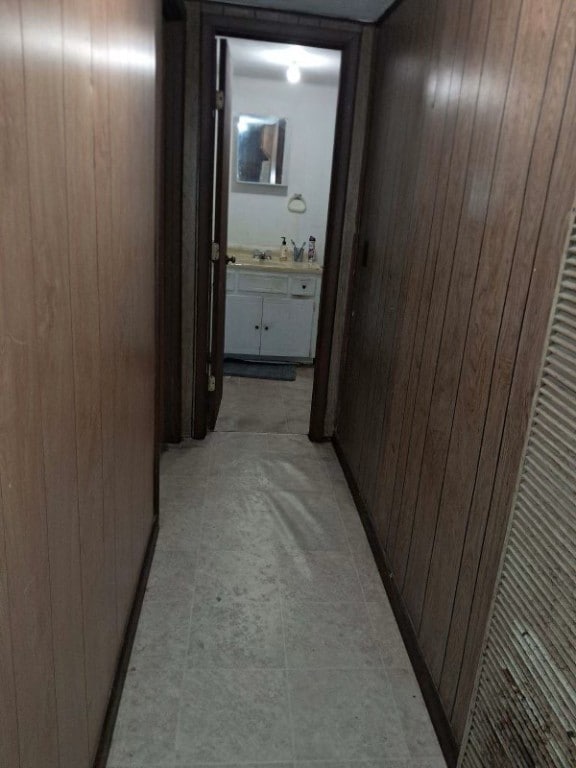 hallway with sink and wood walls