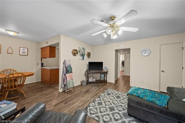 living room featuring dark wood-type flooring and ceiling fan