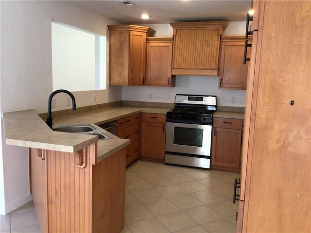 kitchen featuring stainless steel gas range, sink, light tile patterned floors, a kitchen breakfast bar, and kitchen peninsula