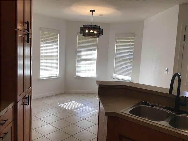 kitchen with decorative light fixtures, sink, and light tile patterned floors