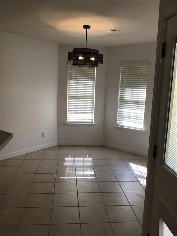 unfurnished dining area with tile patterned floors and a chandelier