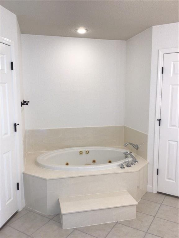 bathroom with tiled tub and tile patterned floors