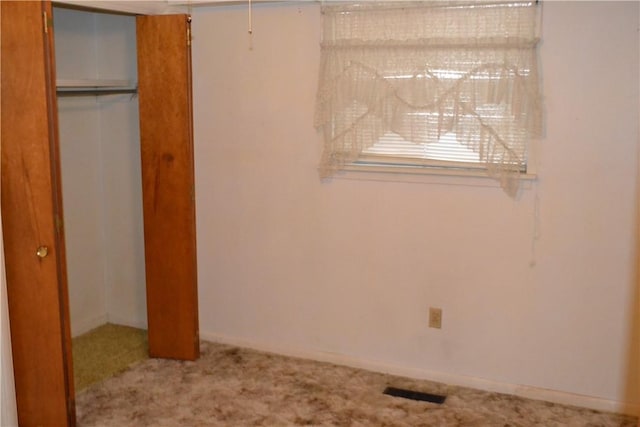 unfurnished bedroom featuring carpet flooring and a closet