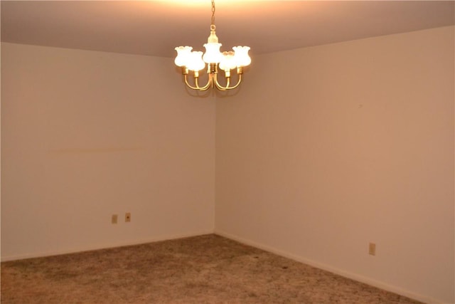 unfurnished room with an inviting chandelier and carpet