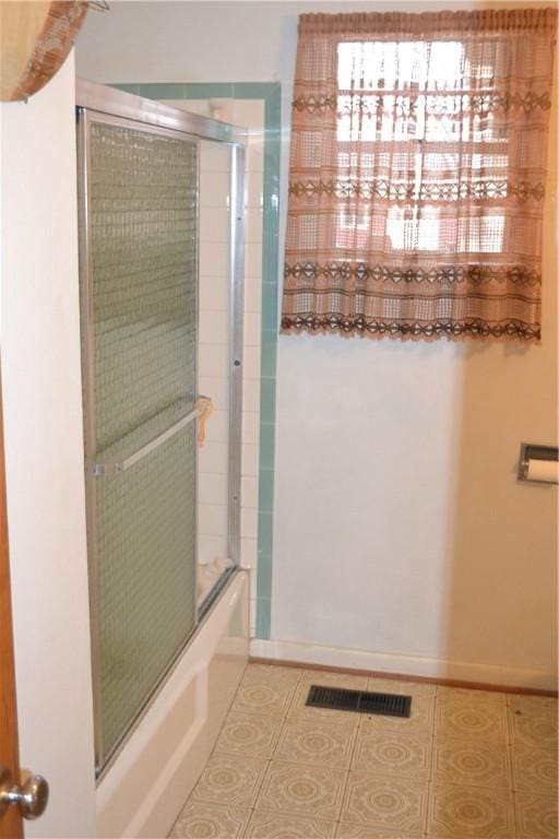 bathroom with tile patterned floors and combined bath / shower with glass door