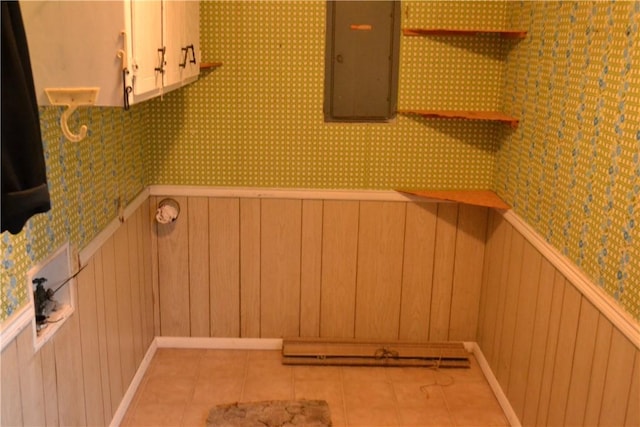 clothes washing area with cabinets, light tile patterned floors, and electric panel