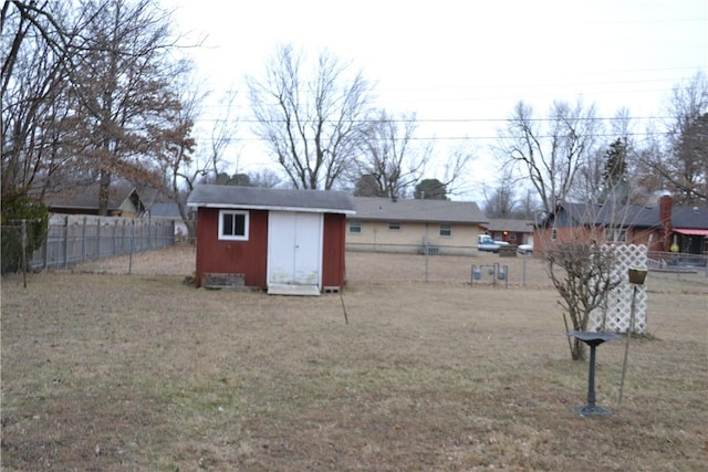 rear view of property featuring a storage shed and a yard