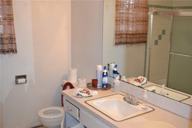 bathroom with vanity, toilet, and walk in shower