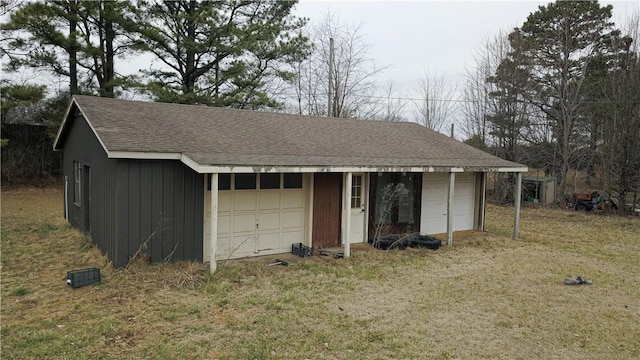 single story home with an outbuilding, a garage, and a front lawn