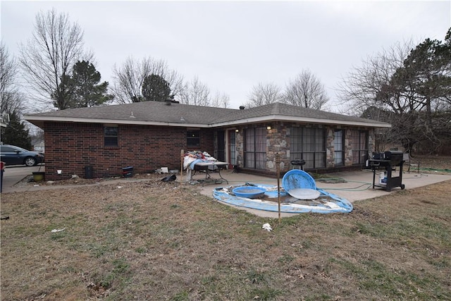 rear view of house with a lawn and a patio