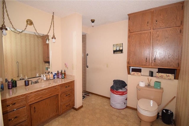 bathroom featuring vanity, a shower, a textured ceiling, and toilet