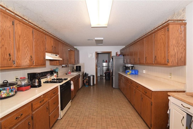 kitchen featuring appliances with stainless steel finishes, decorative backsplash, and a textured ceiling