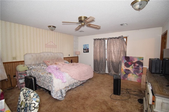 carpeted bedroom with ceiling fan and a textured ceiling