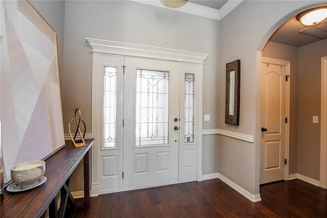 foyer entrance with ornamental molding and dark hardwood / wood-style floors