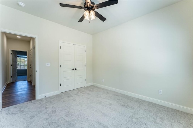 unfurnished bedroom with light colored carpet, ceiling fan, and a closet