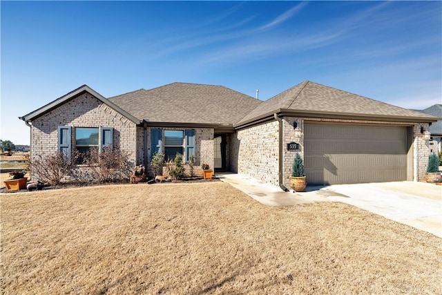 view of front of property featuring a front lawn, driveway, a garage, and roof with shingles