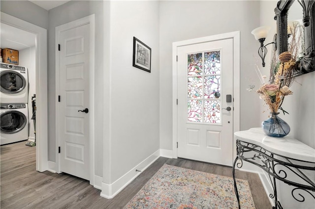 entryway with stacked washer / drying machine and hardwood / wood-style floors