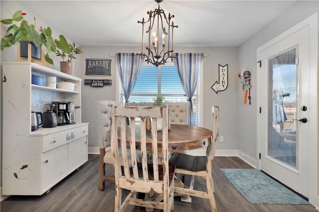 dining room with dark hardwood / wood-style floors and a notable chandelier