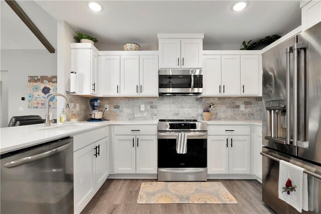 kitchen featuring white cabinetry, backsplash, and stainless steel appliances