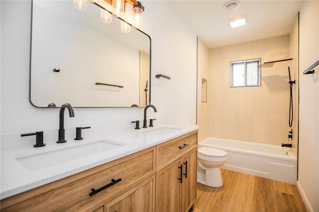 full bathroom featuring vanity, toilet,  shower combination, and hardwood / wood-style floors