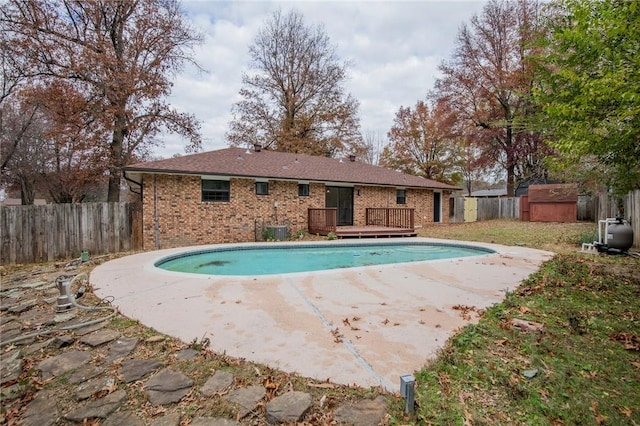 view of pool with a shed and a deck