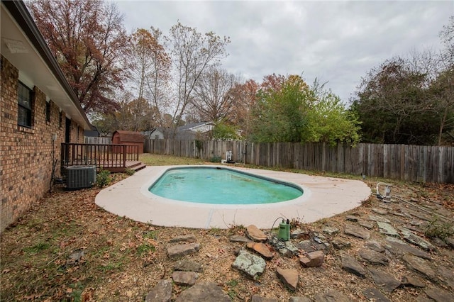 view of swimming pool featuring a wooden deck and central AC