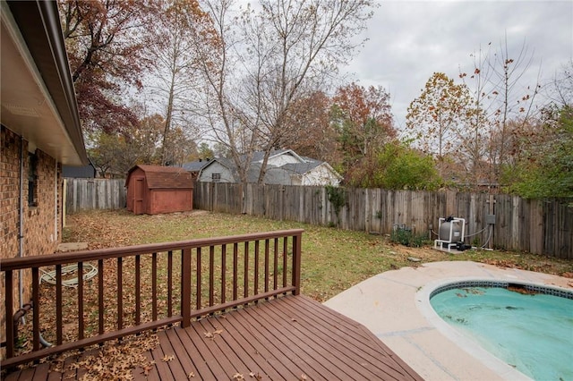 wooden terrace with a storage unit and a fenced in pool