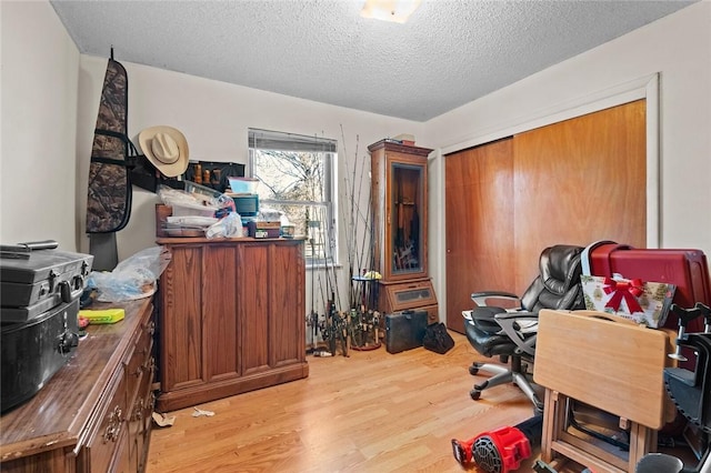 home office featuring a textured ceiling and light hardwood / wood-style flooring