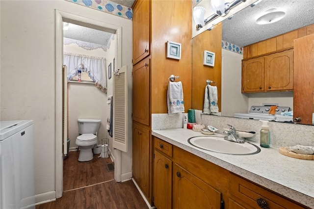 bathroom featuring hardwood / wood-style flooring, vanity, toilet, and a textured ceiling