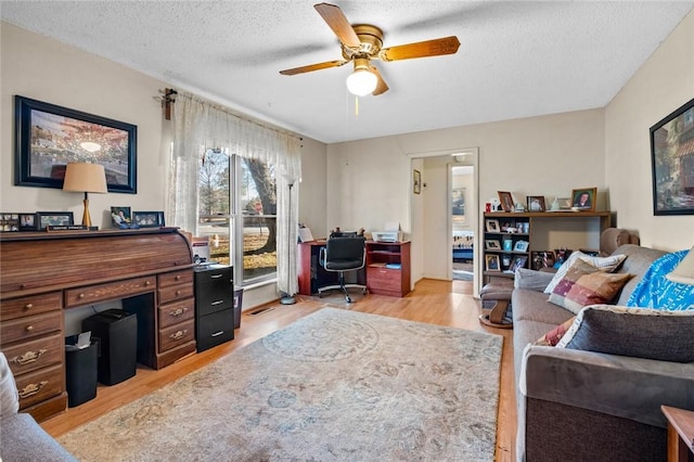 office with wood-type flooring, ceiling fan, and a textured ceiling