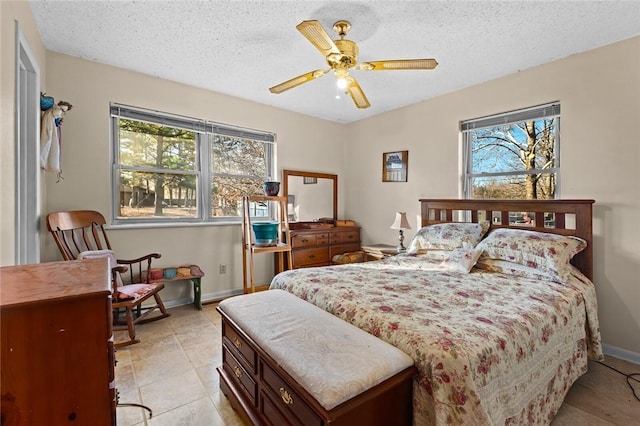 bedroom with light tile patterned flooring, ceiling fan, and a textured ceiling